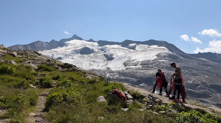 Kletterer stehen am Fels mit Getscher im Hintergrund  | © DAV Allgäu Immenstadt 