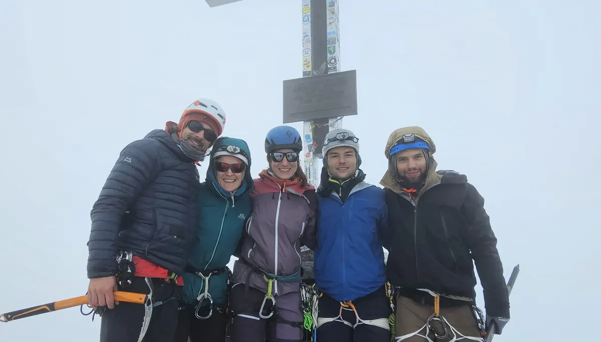 Gruppenbild vor dem Gipfelkreuz mit Nebel im Hintergrund  | © DAV Allgäu Immenstadt 