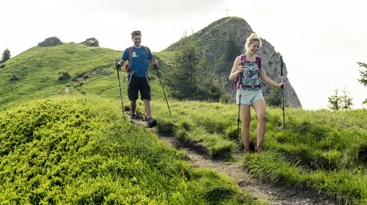Zwei Wanderer auf den grünen Berghängen der Chiemgauer Alpen | © DAV/Hans Herbig
